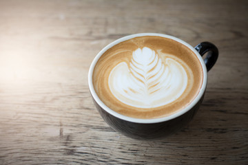 Cup of latte art coffee on wooden background