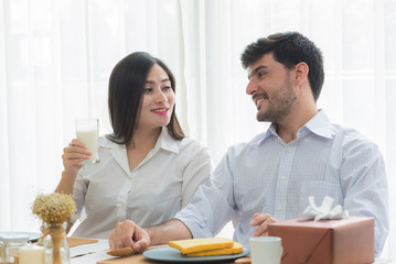 Husband with Pregnant woman having breakfast in dining room