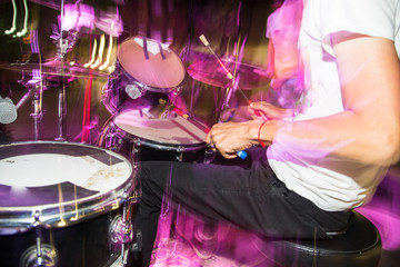 Musician plays drums in a rock band
