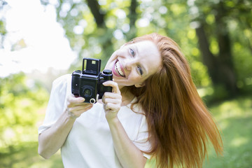 Frau in der Natur mit Kamera 
