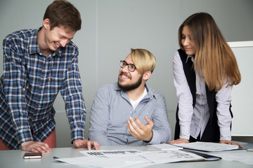 Junior account Manager laughs at this task and tells about it to colleagues, two businessmen laugh...