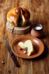 Piece of French Brioche Bun with Chocolate Filling on brown plate, on wooden background.