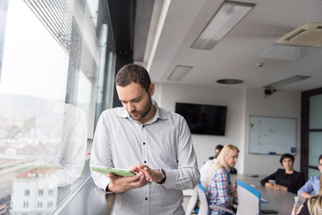 Businessman Using Tablet In Office Building by window