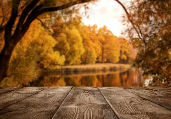 Fotobehang Pier Autumn background, close up of old empty wooden table over the lake with copy space  © rangizzz