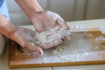 close up hands of young woman with flour
