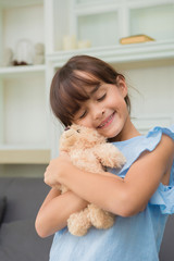 child girl playing with Teddy Bear in living room at home