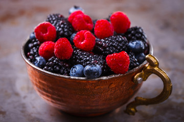 Berry Fresh in a copper cup on the Metal Background. Blackberries,Bramble,raspberry with mint.Food or Healthy diet concept.Super Food.Vegetarian.Copy space for Text.selective focus.