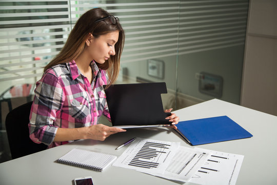 girl working in the office studying documents, business lady examines the many different charts