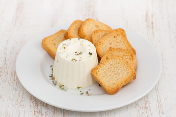 fresh cheese with toasts on white plate