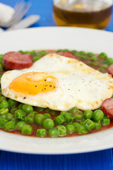 peas with smoked sausage and fried egg on plate