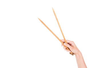 Woman hand holding two wooden knitting needles isolated on white background