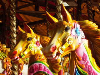 brightly coloured carousel horses on a vintage fairground ride