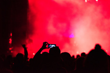 Raised arms holding smart phones to recording a live concert