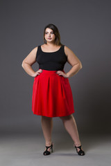 Plus size fashion model in red skirt, fat woman on gray background, overweight female body