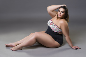 Fototapeta na wymiar Plus size fashion model in sexy swimsuit, young fat woman on gray background, overweight female body