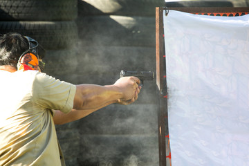 Shooting with a pistol. Man Firing pistol in shooting range.