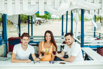 Friends toasting in summer vacation in a bar terrace on the beach
