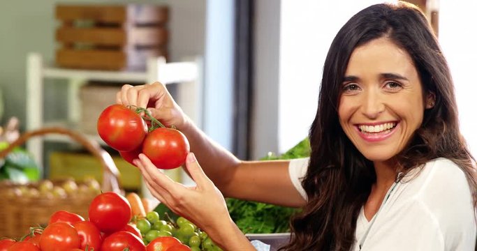 Woman selecting tomatoes in organic section