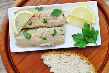 Herring fillet marinated in oil on white plate