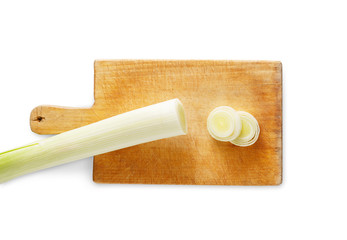 Sliced and chopped leek on wooden cutting board isolated at white background