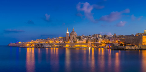 Fototapeta na wymiar Valletta, Malta - Panoramic skyline view of the famous St.Paul's Cathedral and the city of Valletta at blue hour