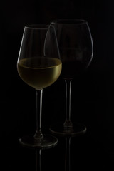 Wine glasses on black - two high glasses of red and white wine