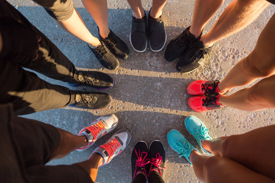 Runners standing in a huddle with their feet together