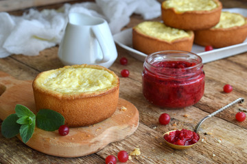 Mini cowberry cheesecake in muffin forms. Served in cutting board with jam and berries. Copy space