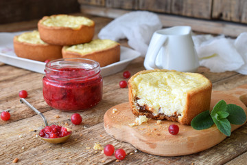 Mini cowberry cheesecake in muffin forms. Served in cutting board with jam and berries. Copy space