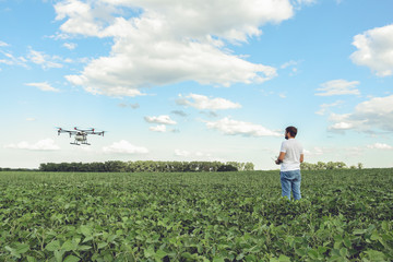 Technician farmer use wifi computer control agriculture drone on green field. Agriculture drone on the green field.