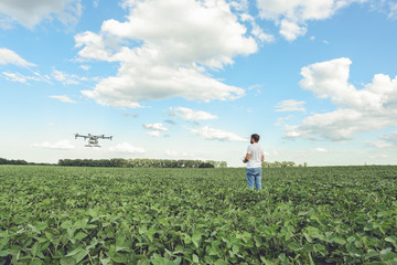 Technician farmer use wifi computer control agriculture drone on green field. Agriculture drone on the green field.