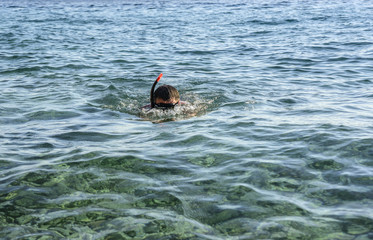 Man in a diving mask in sea water.