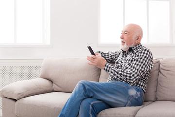 Fototapeta premium Emotional senior man watching tv copy space