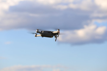 Quadcopter with camera flying on a clear sunny sky sunset background with nice lens flare.