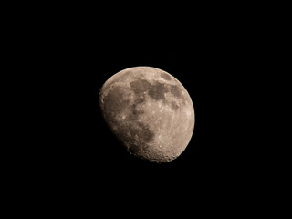 The moon against a black sky, waxing gibbous 82%. Taken in Thailand
