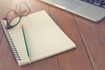 Wooden table with notepad, computer and coffee cup. View from above with copy space.