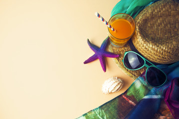 summer season with orange juice drink and prop decor toy and fashion gadget hat on colorful tone with ground in top view