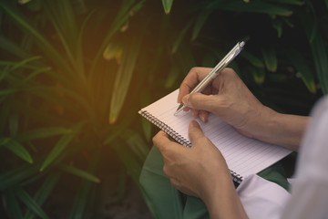 Woman sitting and holding a blue pencil and doing an exam