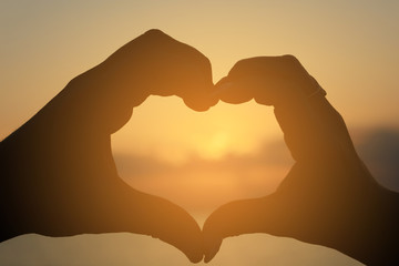 The guy and the girl make from the fingers a heart shape as a symbol of love 