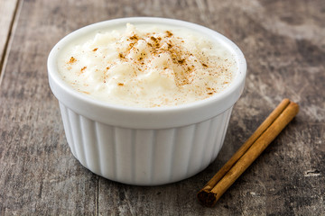 Arroz con leche. Rice pudding with cinnamon on wooden background


