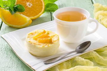 Delicate orange dessert and tea in a cup