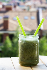 Green smoothie of kiwi,banana,Apple on a white wooden background