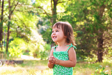 Happy toddler girl wearing bathing suit playing outside