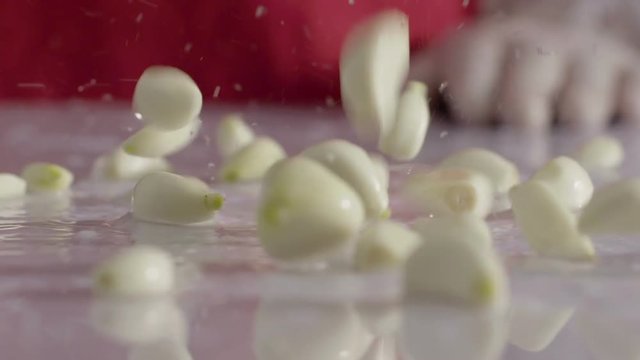 Falling clove of garlic wet kitchen table 