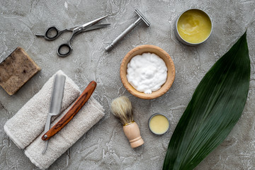 Fototapeta na wymiar Accessories for shaving. Shaving brush, razor, foam, sciccors on grey stone table background top view