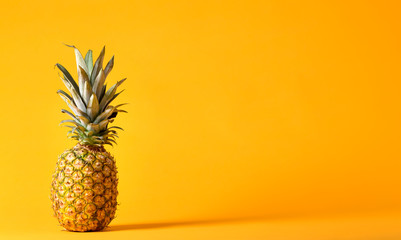 Whole pineapple on a bright yellow background - obrazy, fototapety, plakaty