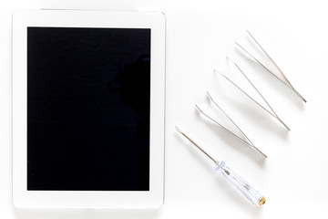 Daignostic of gadgets. Tablet computer and tools on white background top view mockup