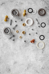 Sink drain parts and plumbing tools on grey stone background top view copyspace