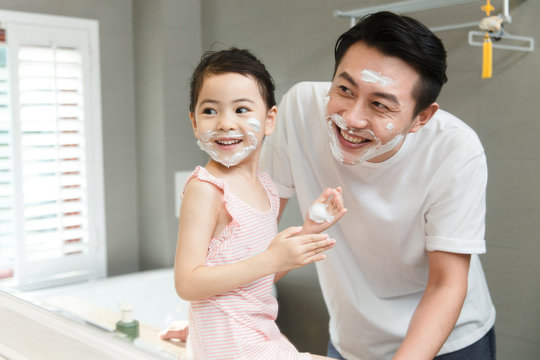 Girl and father with shaving cream on faces
