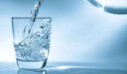  Drinkwater wordt in een glas gegoten © luchschenF